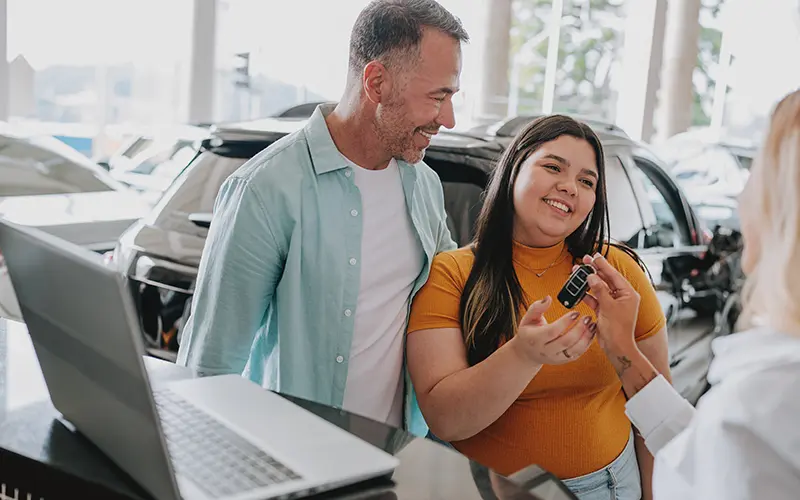 dad and daughter with new car