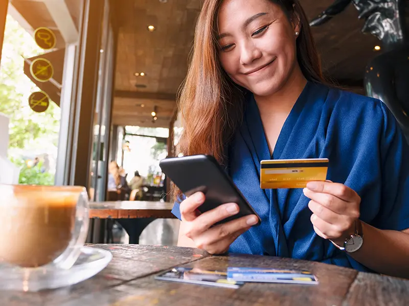 woman paying for coffee with debit card